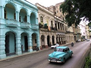 1950s-era American cars constantly cruise by elegant but dirty, grand buildings along the Prado in central Havana. Photo by Andy Brack.